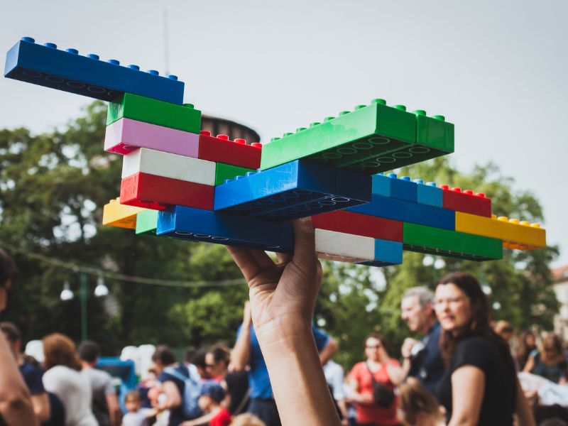 Aus Lego gebautes Objekt mit Familien im Hintergrund in Mailand